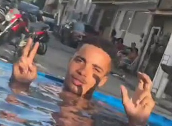 Traficante aparece em foto tomando banho de piscina em plena rua na Gardênia Azul (CV) fazendo símbolo da facção com as mãos